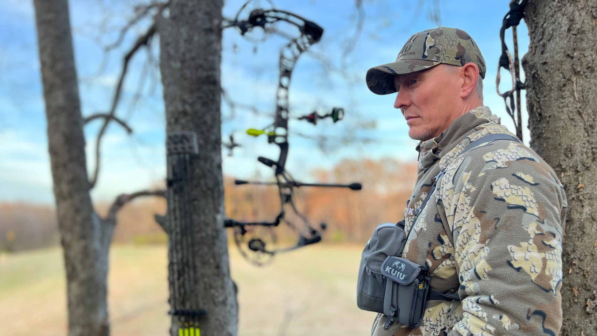 Side of Hunter Standing in Tree Stand Wearing Proximity Hooded Insualted Jacket Highlighting Removable Hood