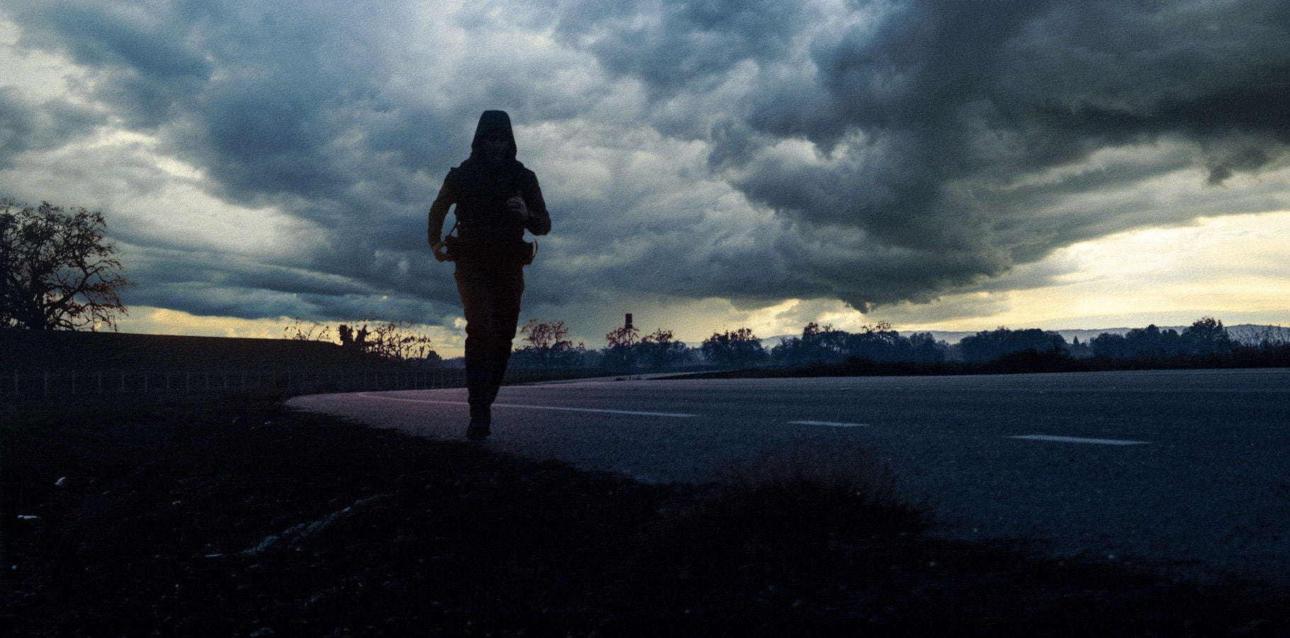 Silhouette of man running along a street