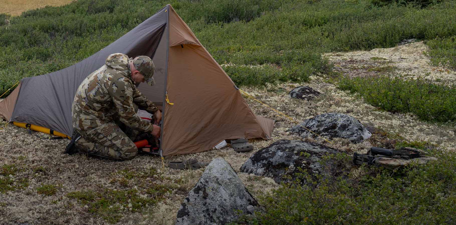 Justin shaffer in Valo camouflage staking out a Summit Star 1 person tent