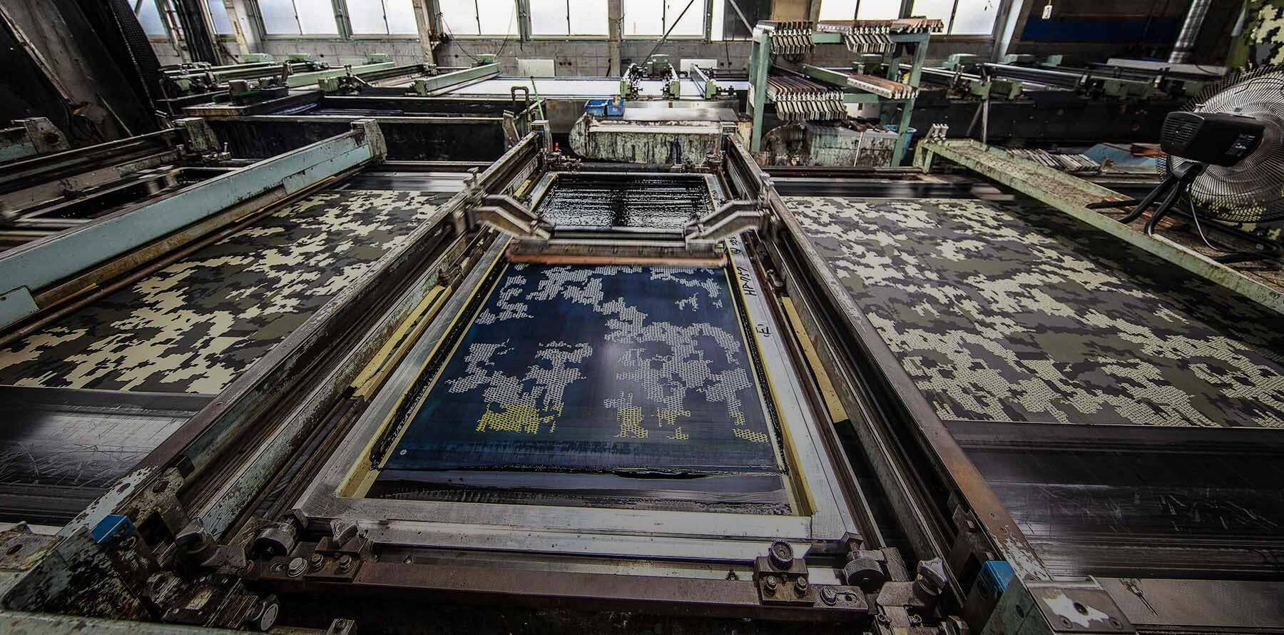 A factory producing fabric panels of Verde camouflage material