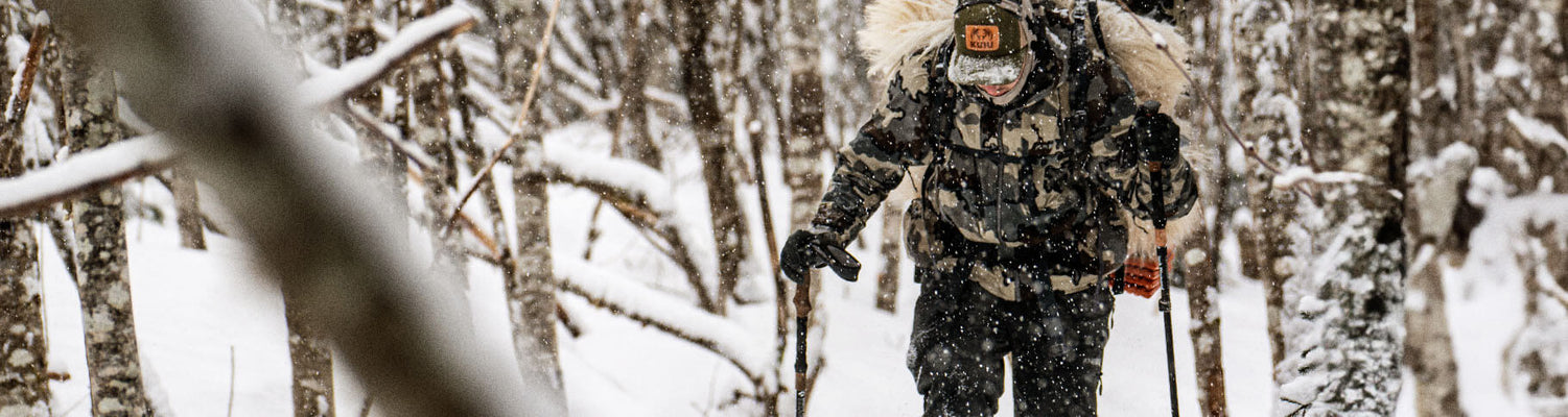 Hunter trekking through snowy weather after successful hunt