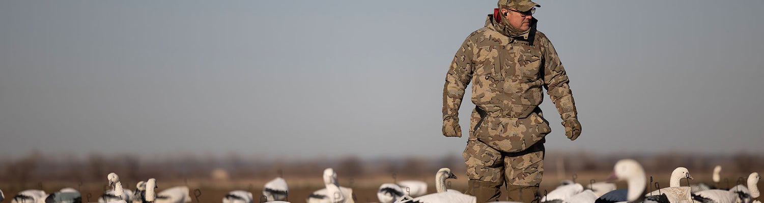 Waterfowl Hunter standing in a field of snow goose decoys 