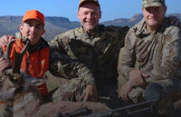 Gold star hunt recipient seated with his guides and harvested pronghorn