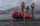 Image showing three hunters standing next to an orage inflatable raft beached on the shoreline as they look through binoculars into the distance