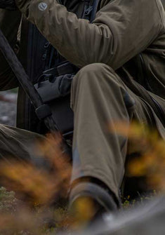 Front, Angled View of Hunter Glassing Game Wearing Kutana Storm Shell Jacket and Pants in Ash Brown Color