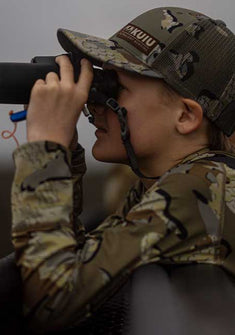 Youth hunter in Valo Camouflage looking through binoculars