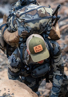 Hunter packing out successful sheep hunt wearing Vias Camouflage