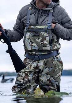 Waterfowl hunter in knee deep water wearing KUIU HD Flex Wader in Valo Camouflage and Flyway Insulated Hooded Jacket in Gunmetal Grey