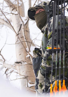 Hunter in tree stand in snowy conditions wearing Proximity Hooded Insulated Jacket in Verde Green Camouflage 