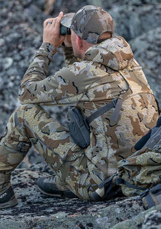 Rear, Angled View of Hunter Glassing Game from Rocks Wearing Valo Camouflage