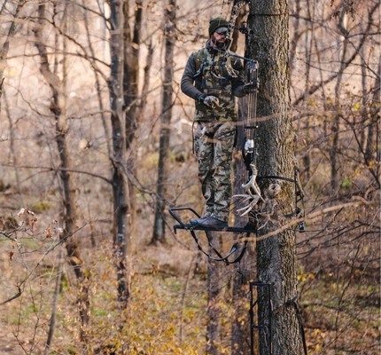 Male hunting Whitetail deer in tree stand.