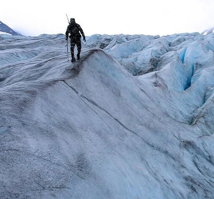 Front of Hunter Hiking Over Glacier Field Wearing Vias Camouflage